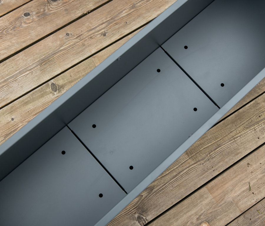 Draufsicht auf einen grauen Pflanzkasten mit Einlegeboden auf einem Holzdeck. Der Pflanzkasten mit Einlegeboden ist ca. 27 cm.