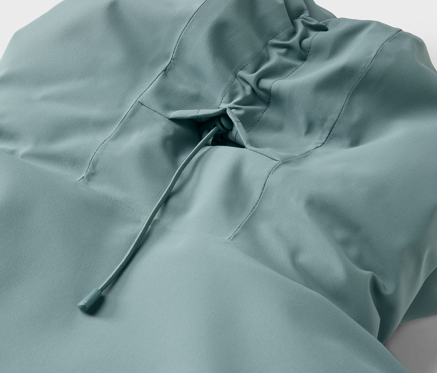 Detailaufnahme einer hellblauen Jacke mit Kapuze und Kordelzug.