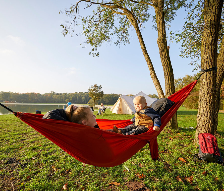 Mutter und Kind entspannen in der roten Grand Canyon Bass Hammock Hängematte im Freien.