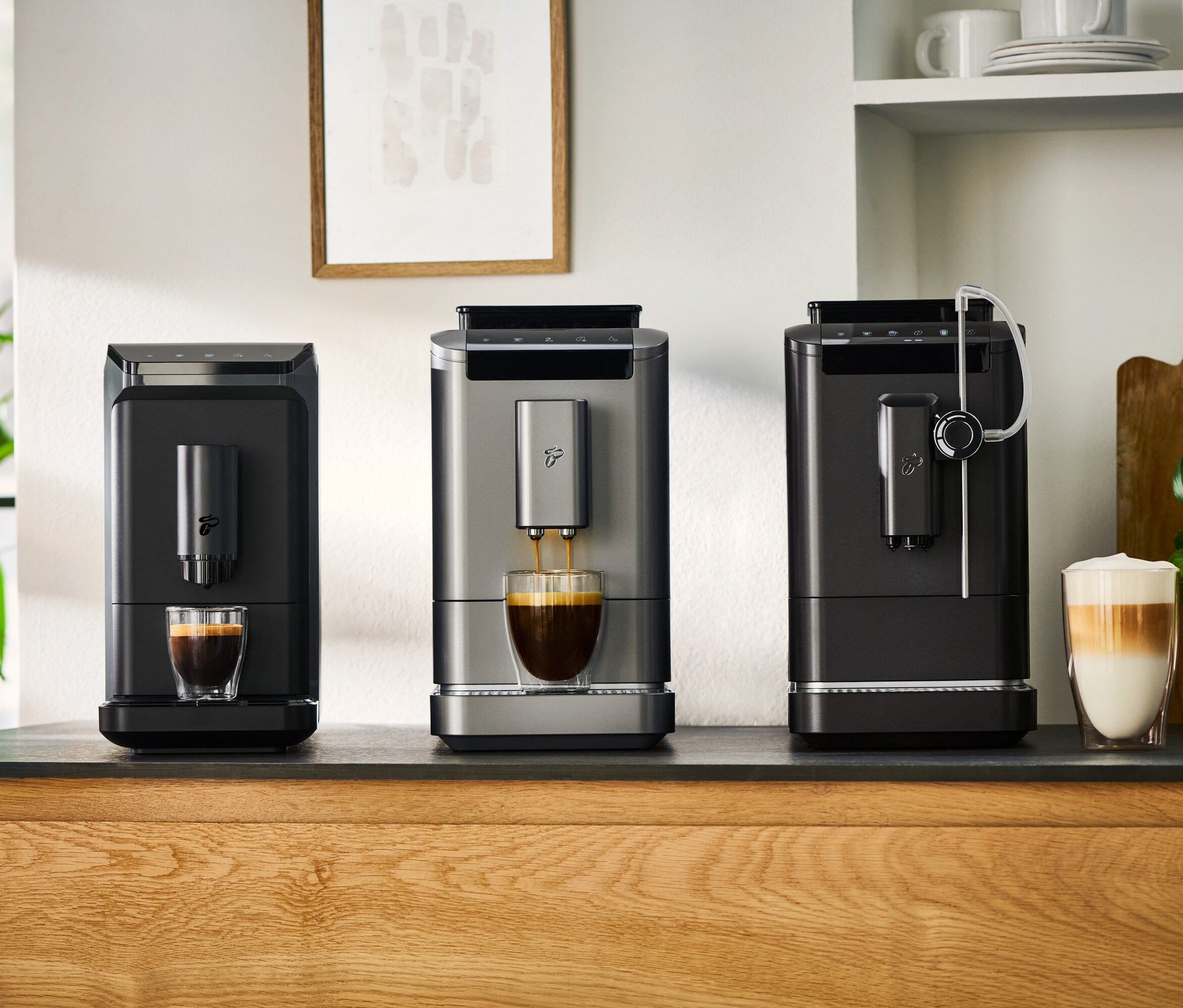 Drei Kaffeemaschinen stehen auf einer Küchentheke.