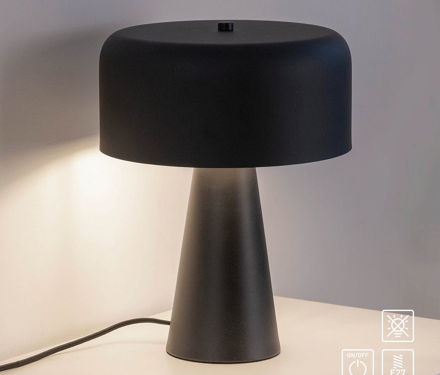 Eine schwarze Tischleuchte steht auf einem weißen Tisch.