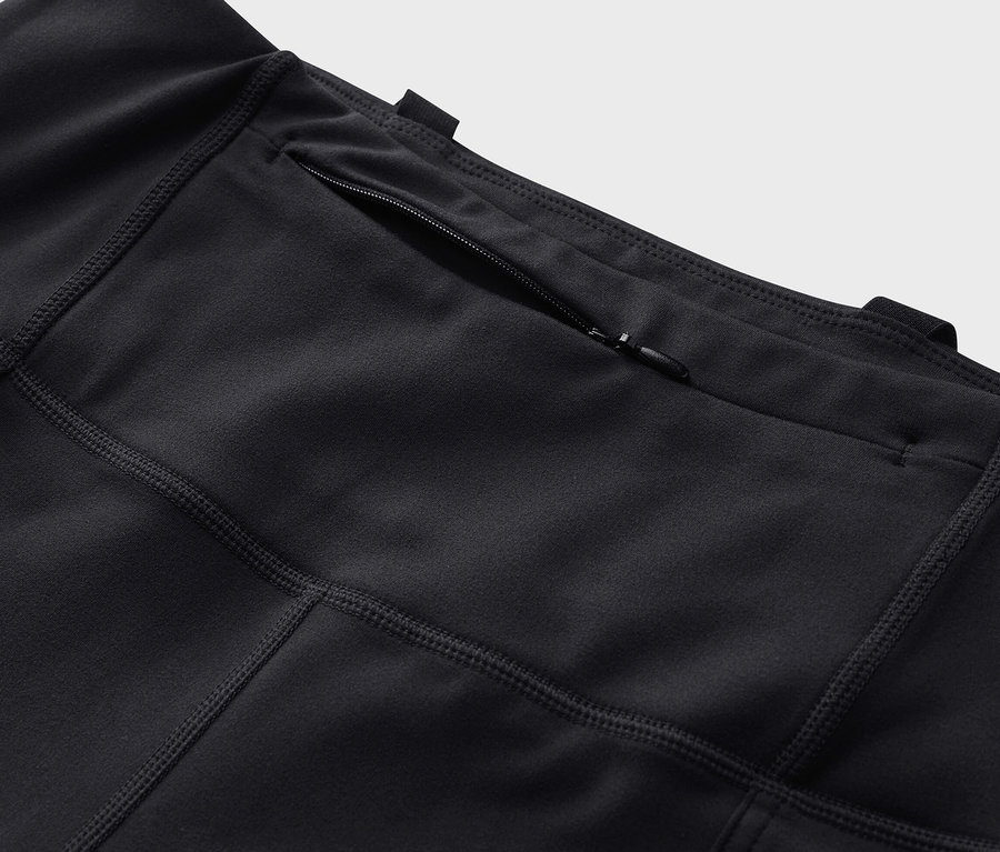 Detailaufnahme einer schwarzen Outdoor-Tight mit Reißverschlusstasche.