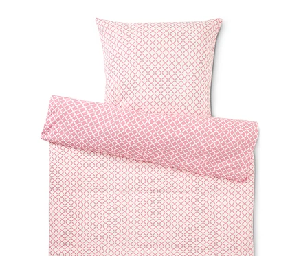 Nahaufnahme von einem Bettbezug und einem Kissenbezug mit einem rosa-weißen Muster.