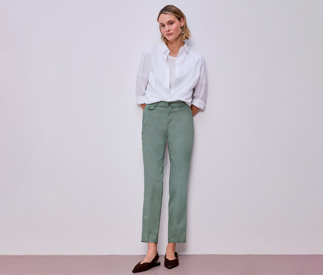 Frau in weißem Hemd und Street One Chino in Mint. Dazu trägt sie braune Schuhe.