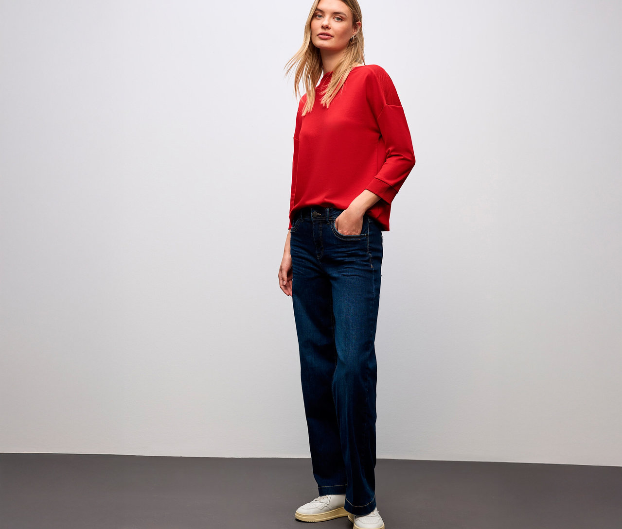 Frau mit rotem Street One T-Shirt mit Rippdetail und Jeans.