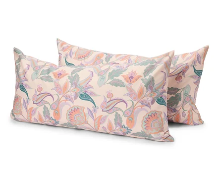 Drei rechteckige Kissen mit einem hellen, floralen Muster liegen übereinander.