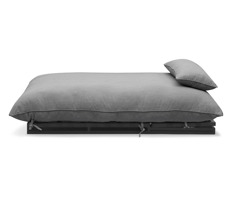 Graues Futonbett mit Kissen auf dunklem Lattenrost.
