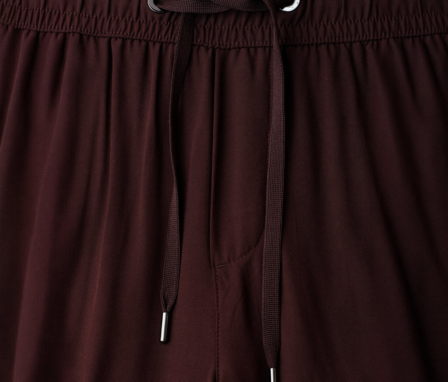 Nahaufnahme des Bundes einer braunen Street One 7/8-Culotte »EMMA« mit elastischem Bund und braunem Kordelzug mit silberfarbenen Metallenden und Ösen.