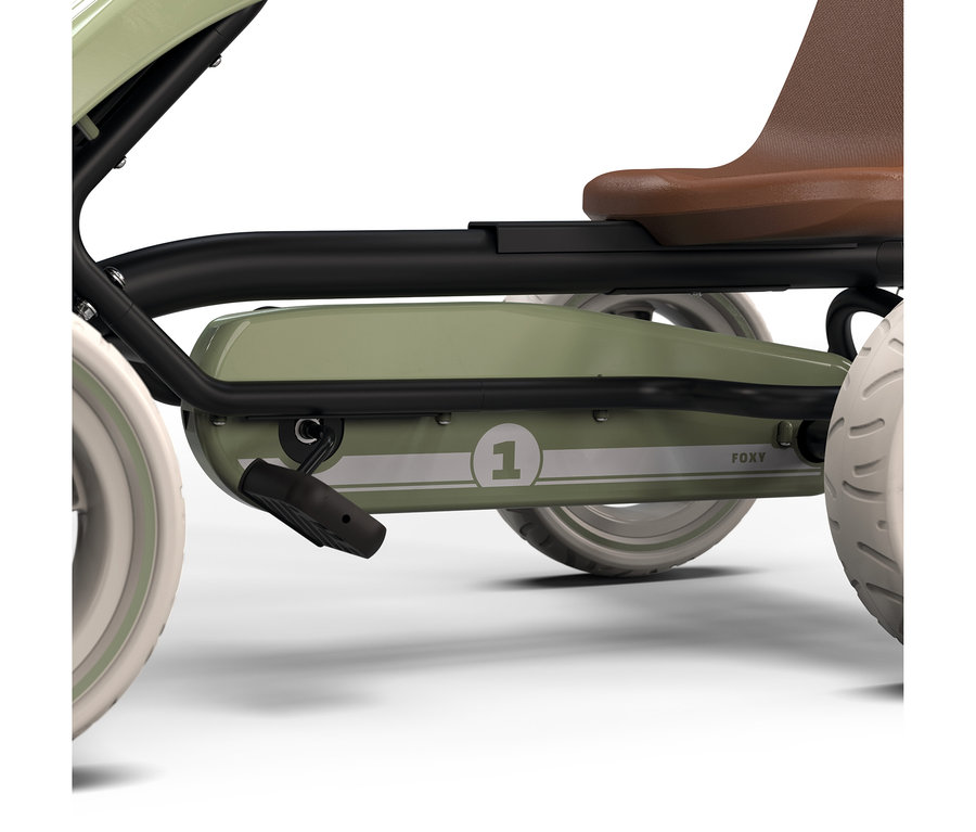 Nahaufnahme einer grünen Tretkart von der Seite mit schwarzem Rahmen, braunem Sitz und weißen Rädern. Ein schwarzes Pedal ist sichtbar, und die Zahl „1“ sowie „FOXY“ stehen auf der grünen Karosserie.