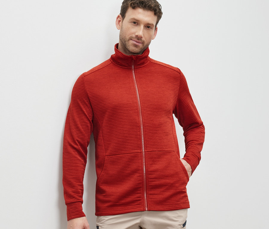 Mann trägt rote Funktionsjacke.