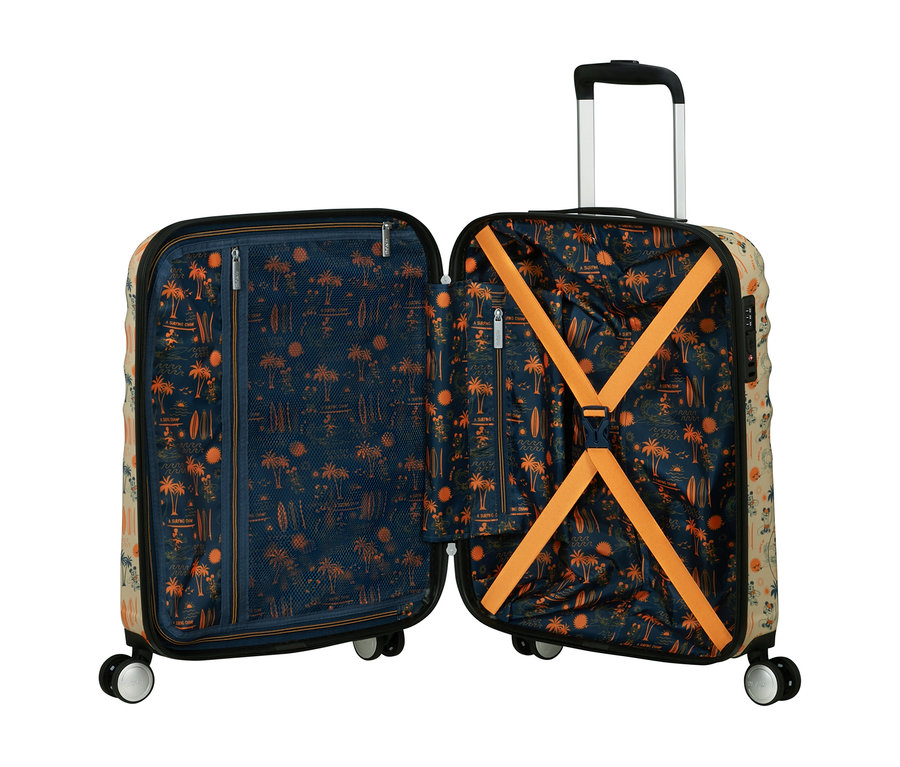 Offener beiger Koffer mit ausgefahrenem Griff und vier Rollen. Das Innenfutter ist dunkelblau mit orangefarbenen Palmen-, Surfbrett- und Sonnenmustern. Eine Seite hat eine Netztasche mit Reißverschluss, die andere orangefarbene Kreuzgurte.