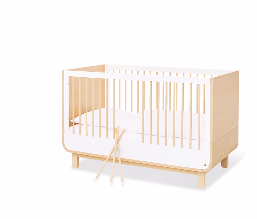 Pinolino Kinderbett »Round« mit weißer Bettwäsche und Holzstäben.