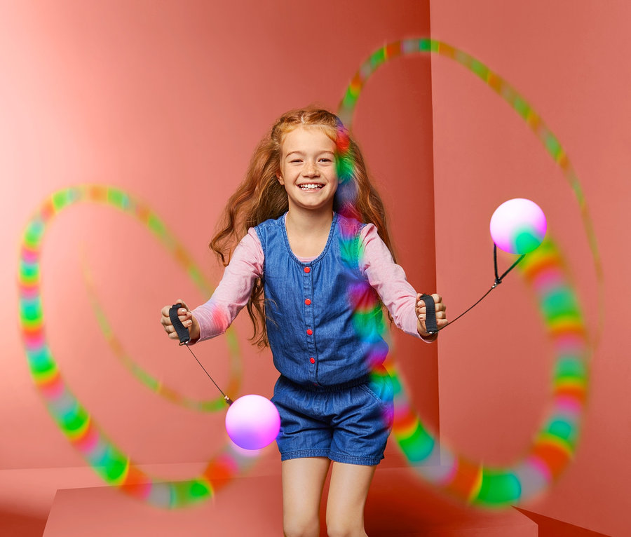 Mädchen jongliert mit einem Paar LED-Pois.