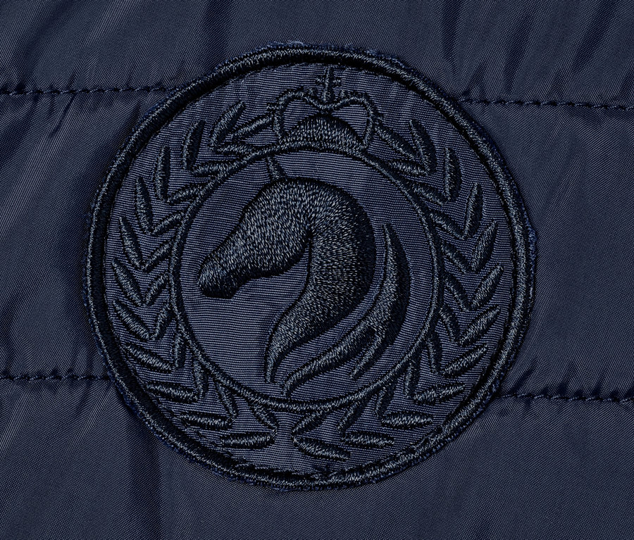 Detailaufnahme einer Reitjacke mit recyceltem Material, mit einem Pferde-Logo.