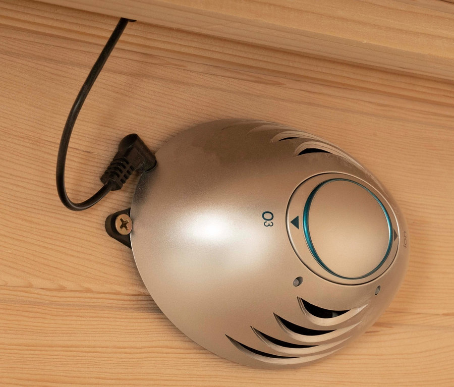 Eine silberne Home-Deluxe-Infrarotkabine »REDSUN M« Ozonlampe ist an einer Holzwand befestigt.
