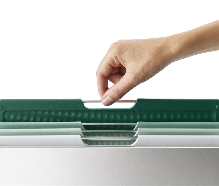 Eine Hand nimmt ein grünes Schneidebrett aus dem Joseph Joseph großes Schneidebrett-Set »Folio™«.