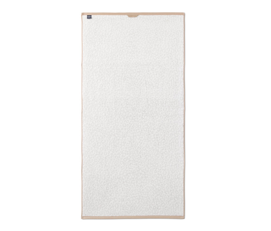Ein weißes Premium-Jacquard-Badetuch im Leo-Dessin mit beigem Rand.