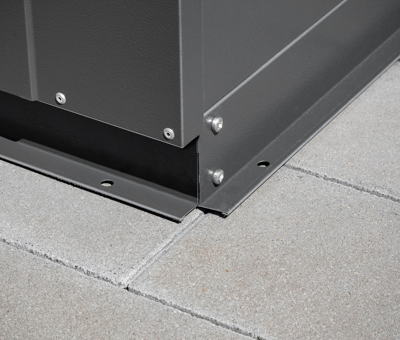 Detail einer Ecke der Trimetals Gerätebox »Storeguard« auf Betonpflaster.