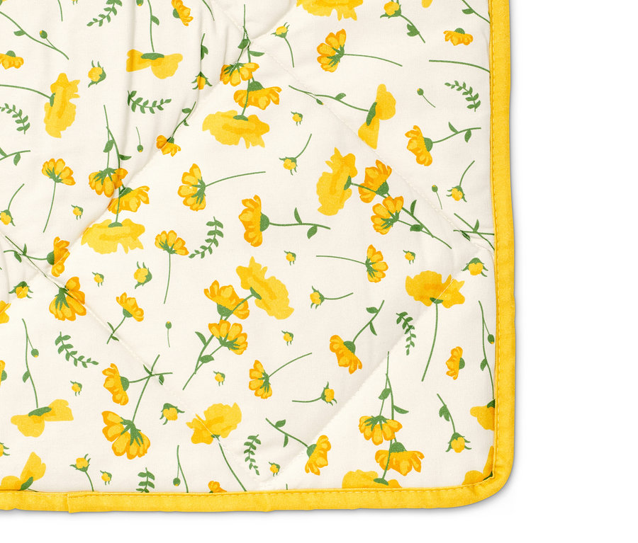 Detail einer wattierten Picknickdecke mit Blumenmuster.