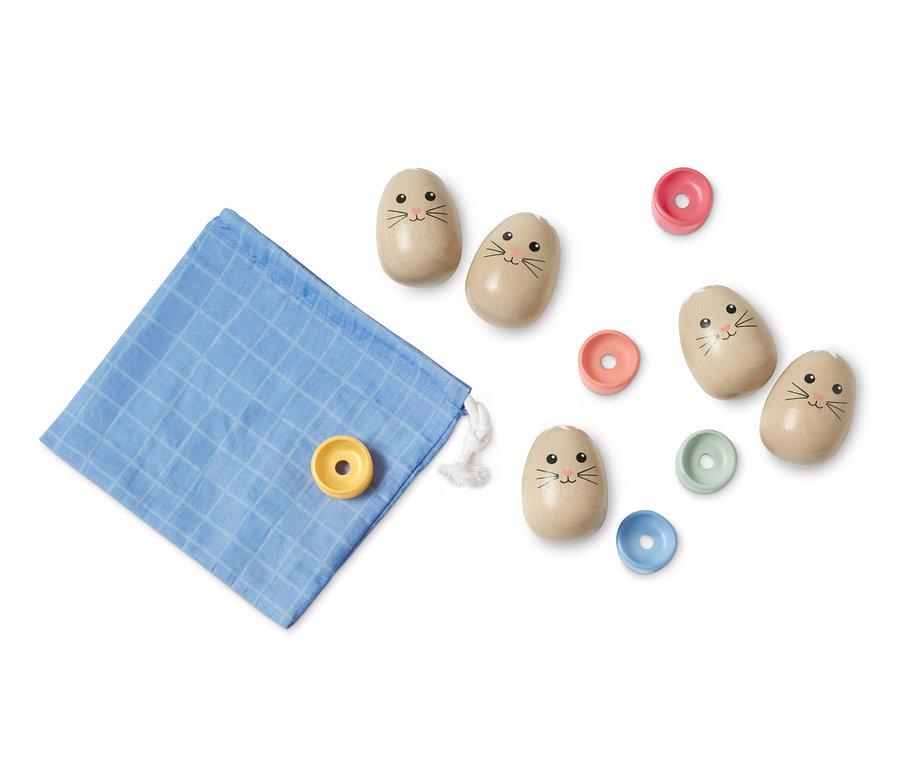 Ein Eier-Stapelspiel liegt ausgebreitet mit einem blauen Stoffbeutel.