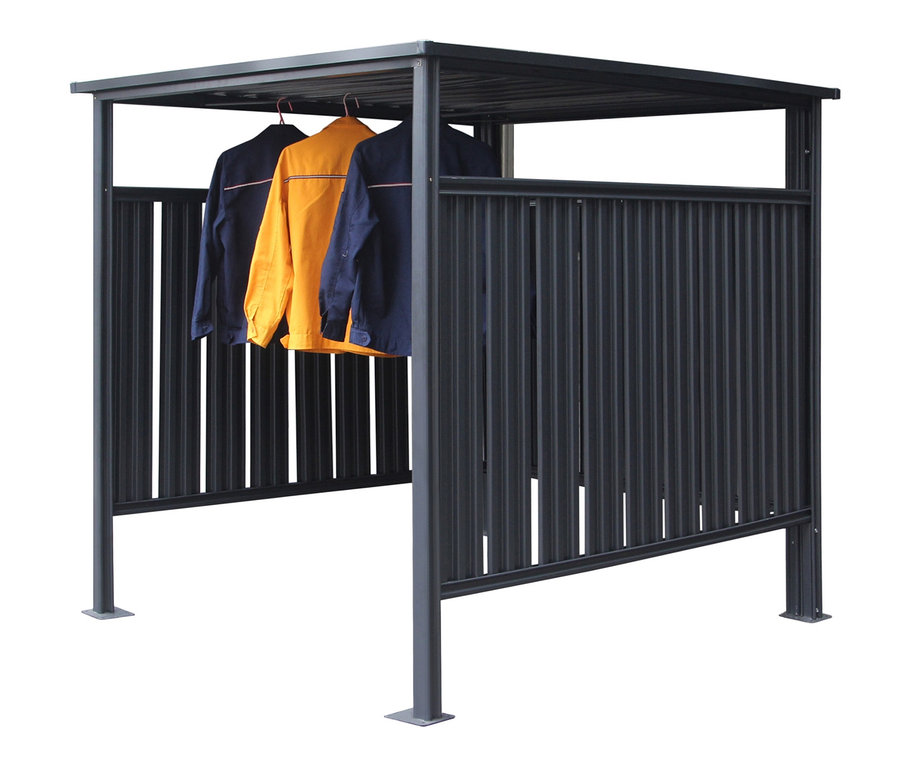 Drei Jacken hängen in einem grauen Fahrradunterstand.