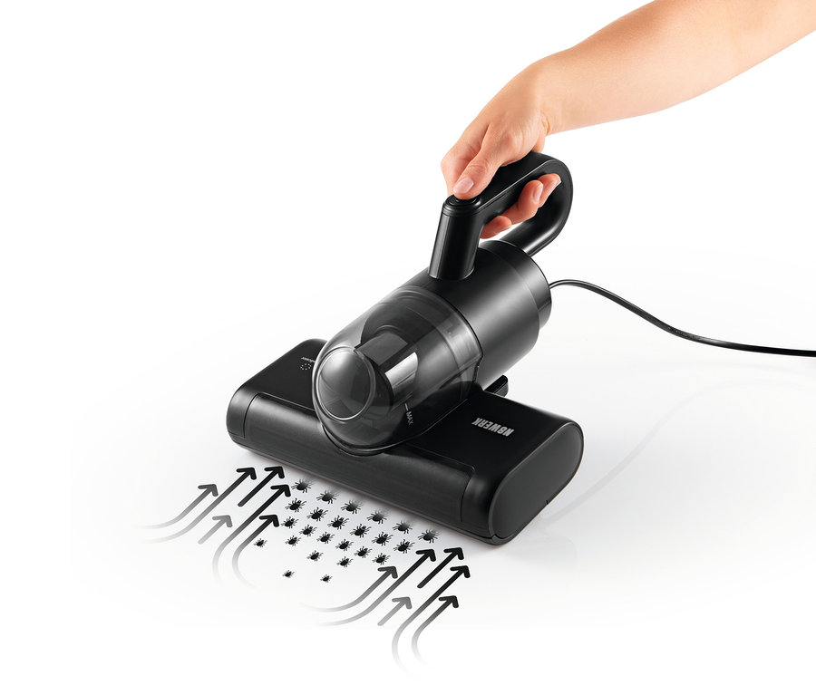 Hand hält schwarzen N8WERK Milbensauger mit pulsierender Bürste über eine Oberfläche, Pfeile zeigen die Saugrichtung an.