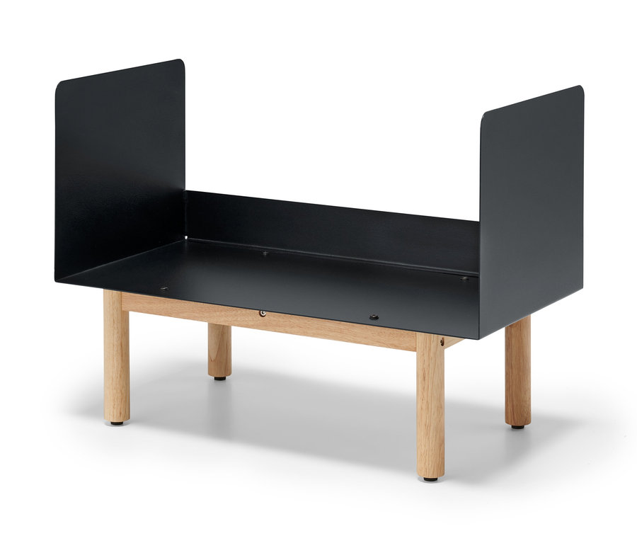 Schwarzes Kaminholz-Regal steht auf vier hellen Holzbeinen.