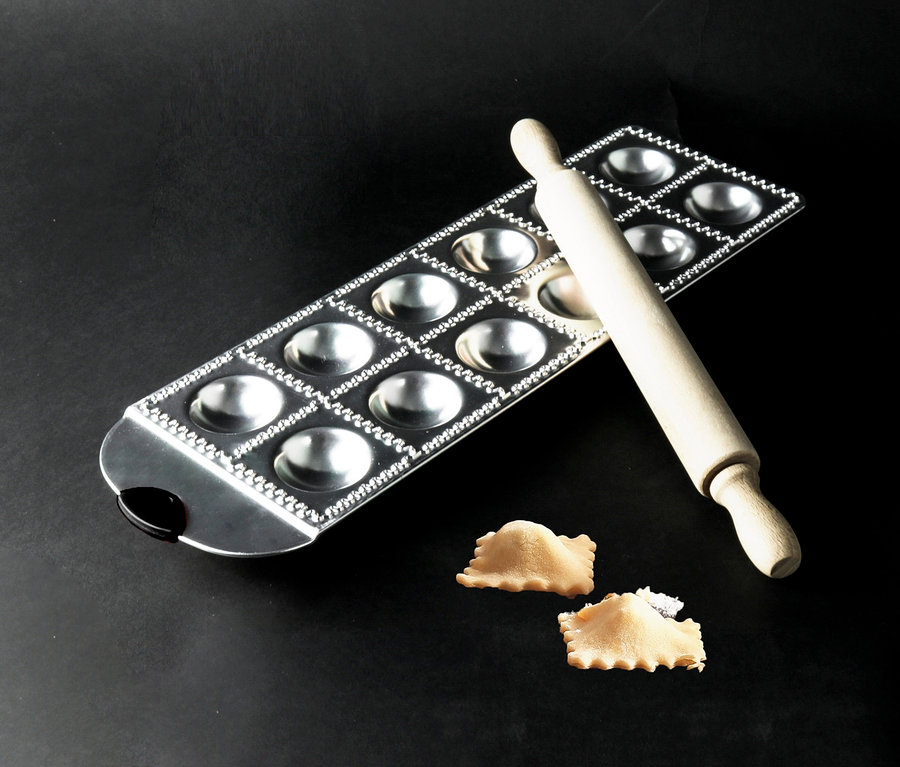 Auf einem schwarzen Hintergrund befindet sich ein Ravioli-Set mit einem Nudelholz und zwei Ravioli.