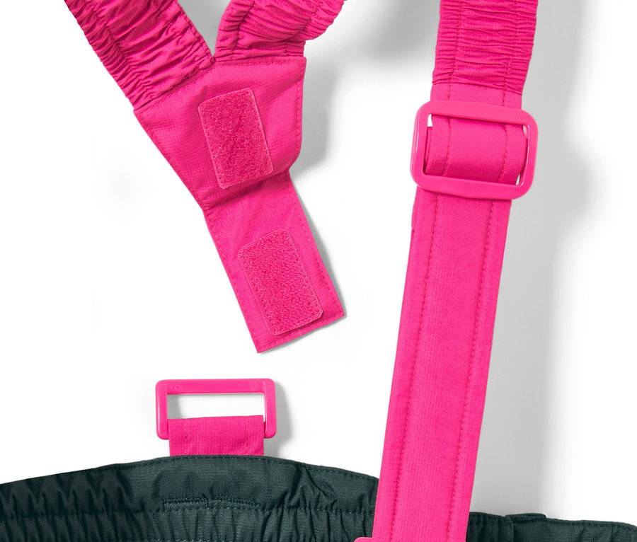 Detailaufnahme einer dunkelgrünen Kinder-Skihose mit pinkfarbenen, verstellbaren Hosenträgern.