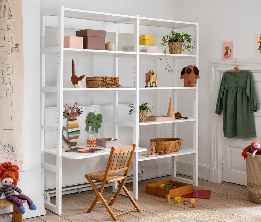 Ein weißes Hoppekids »Storey« Regal mit Spielzeug und Dekorationen in einem Kinderzimmer.