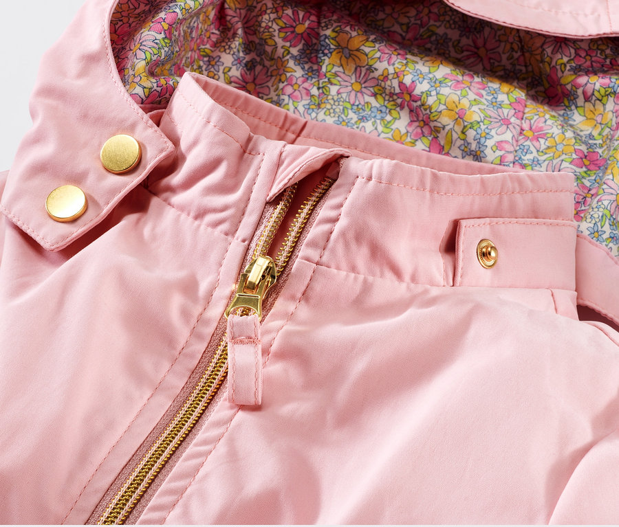 Detailansicht einer rosa Kleinkind-Parka mit Blumenfutter und goldenem Reißverschluss.