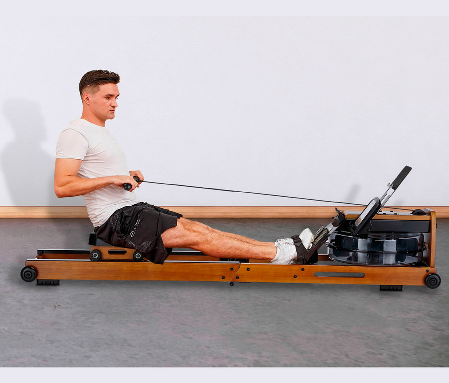 Mann trainiert auf dem Bodycoach Wasser Rudergerät »Wood Compact«.