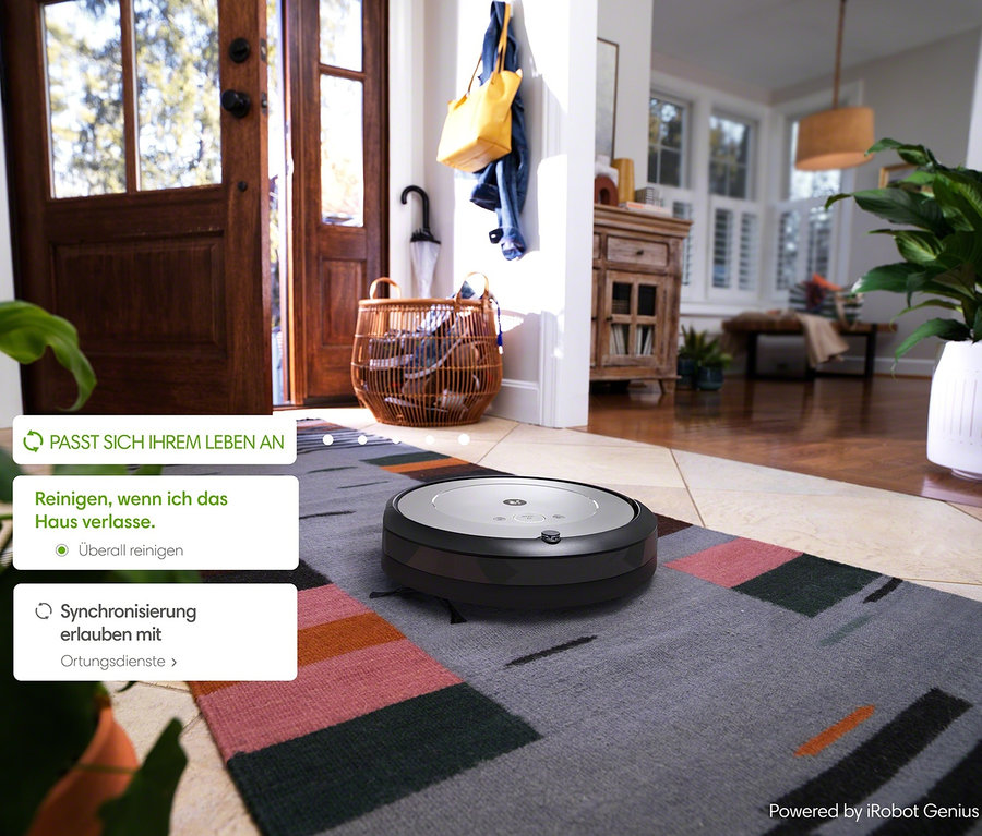 iRobot Saugroboter Roomba i1 saugt bunten Teppich im Flur.