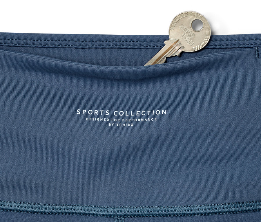 Detail einer blauen 7/8-Sporttight mit einem silbernen Schlüssel in der Tasche.