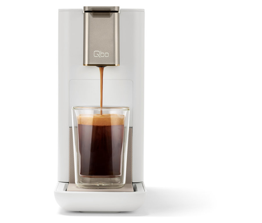 Kaffee fließt aus einer Kaffeemaschine in ein Glas.