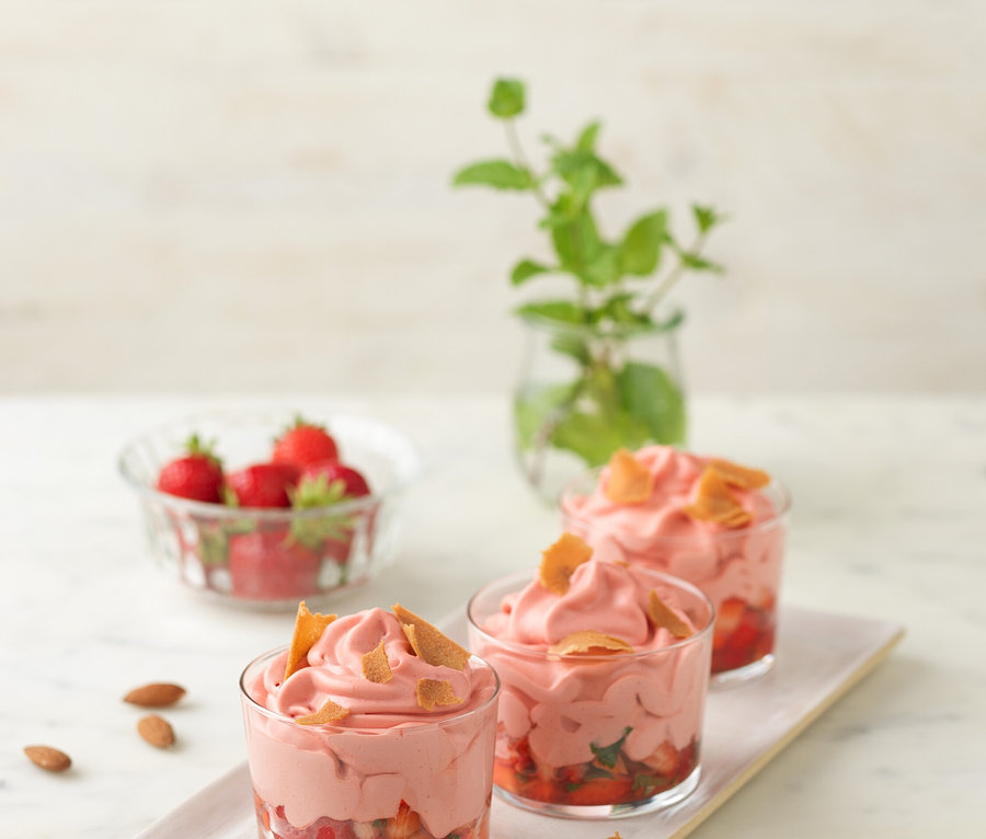 Drei Gläser mit Erdbeerdessert und ISI Creative Whip, 0,5 l auf einem Tisch.