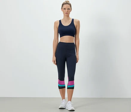 Frau trägt Sport-BH und 3/4-Sporttight.