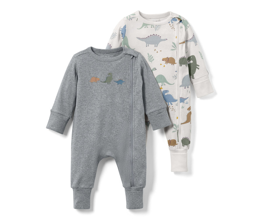 Zwei Baby-Pyjamas mit Dinos. Ein grauer mit kleinen Dinos, der andere weiß mit Dino-Print.