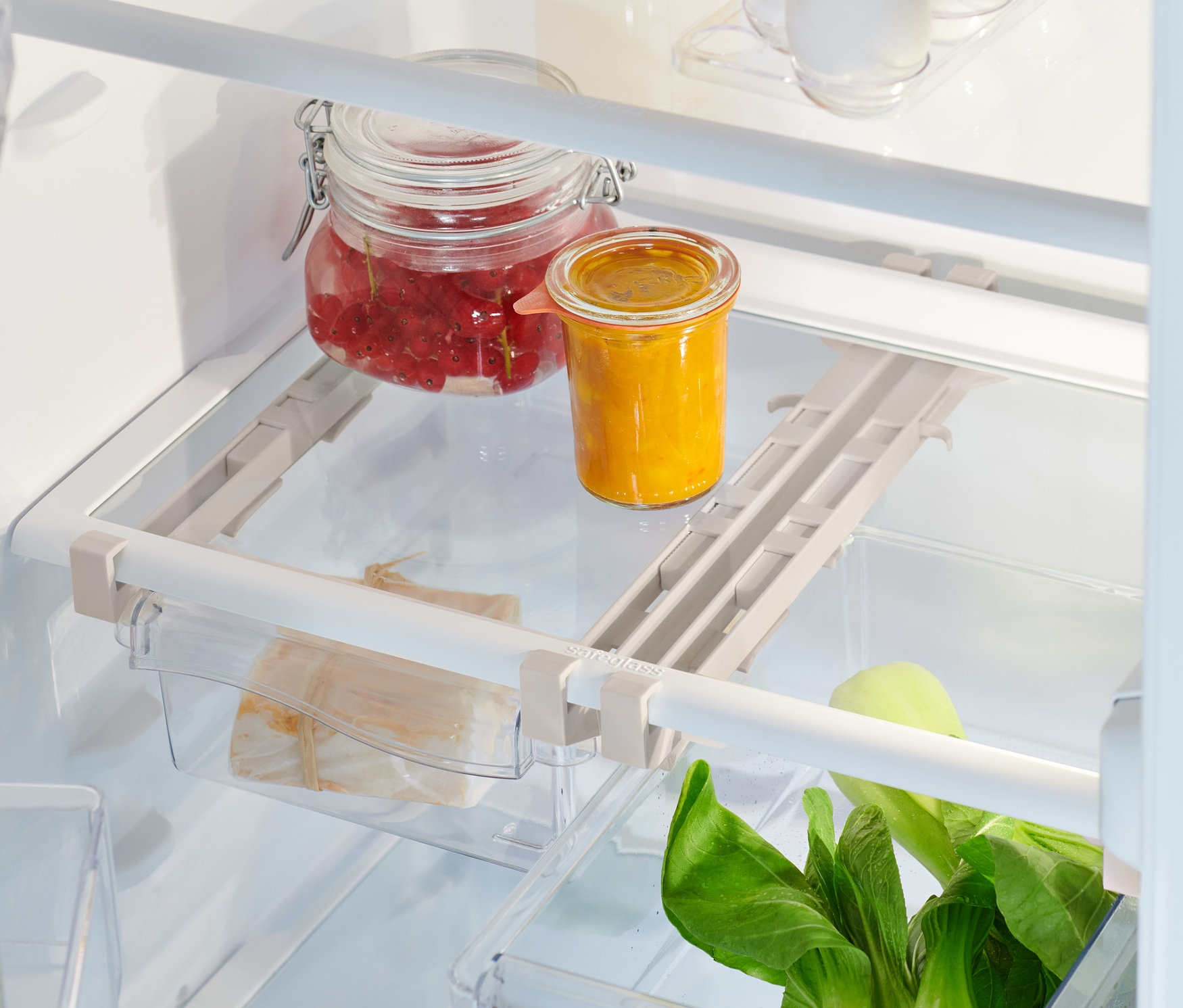 Innenansicht eines Kühlschranks mit Lebensmitteln und 2 ausziehbaren Kühlschrankkörben.