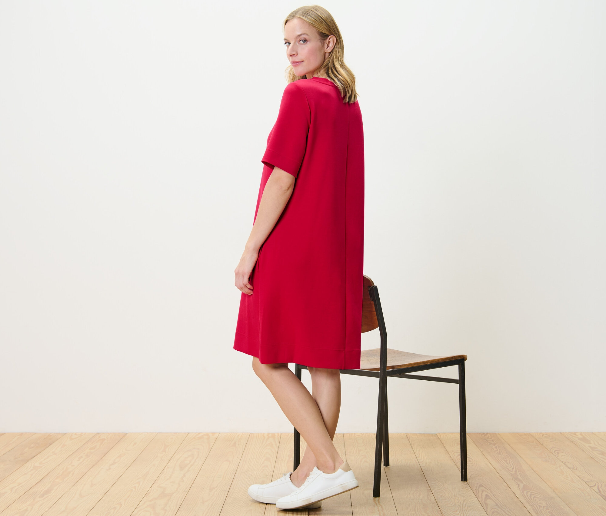 Frau posiert in rotem Sweatkleid.