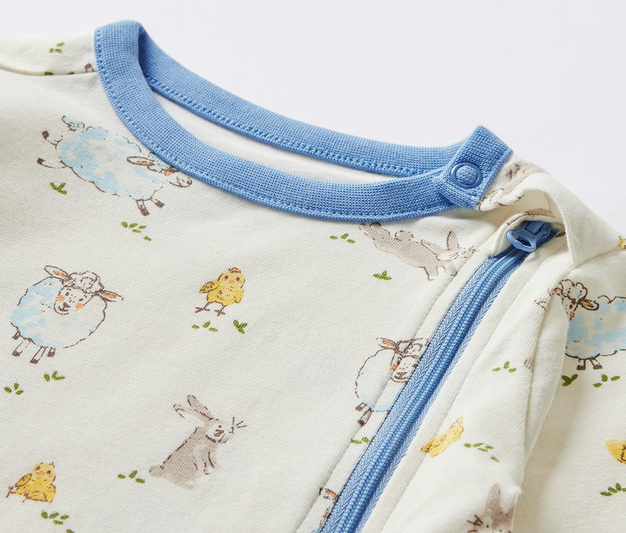 Detailansicht eines Baby-Pyjamas mit Tiermotiven.