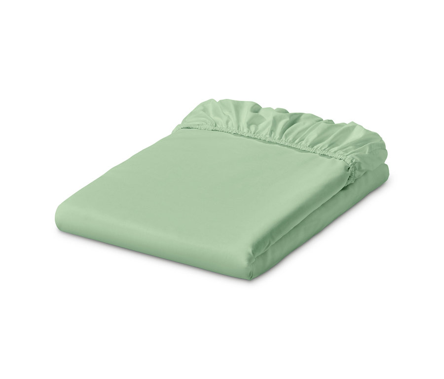 Ein hellgrünes Jersey-Spannbettlaken liegt gefaltet.
