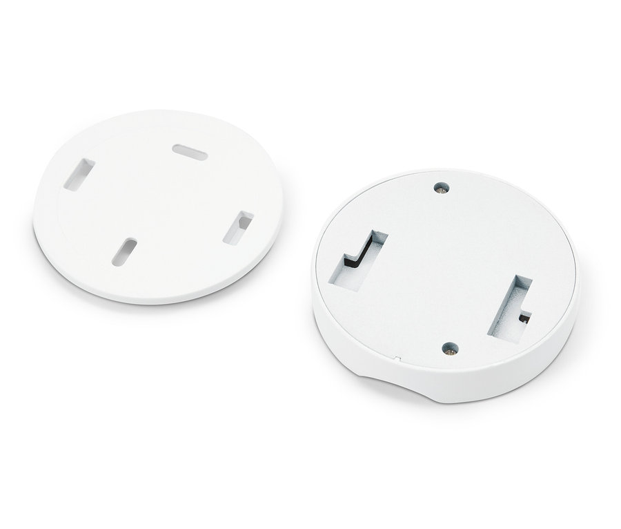 Zwei weiße runde Platten mit Öffnungen liegen auf einem weißen Hintergrund.