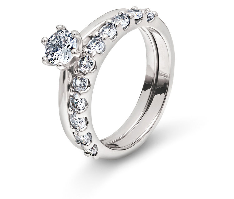 Zwei silberne Ringe mit klaren Steinen auf weißem Hintergrund.