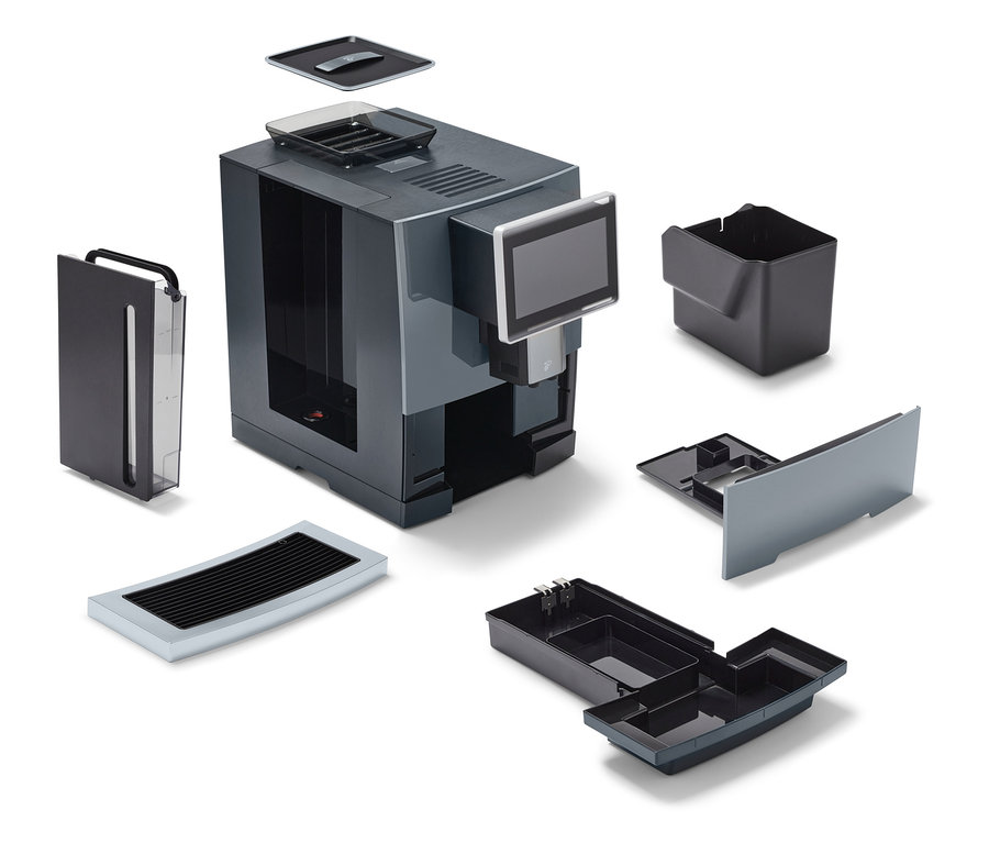 Ein zerlegter Profi-Kaffeevollautomat »Tchibo Office«, schwarz, mit verschiedenen abnehmbaren Teilen.