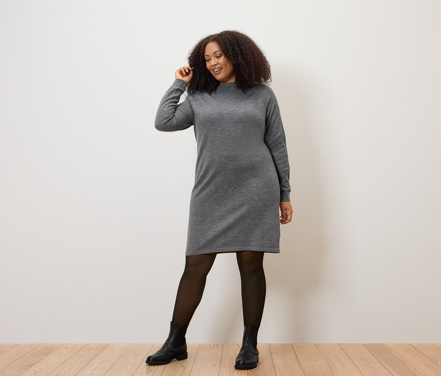 Frau posiert in Strickkleid.