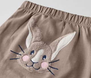 Detailaufnahme einer Babyhose mit Hasenapplikation.