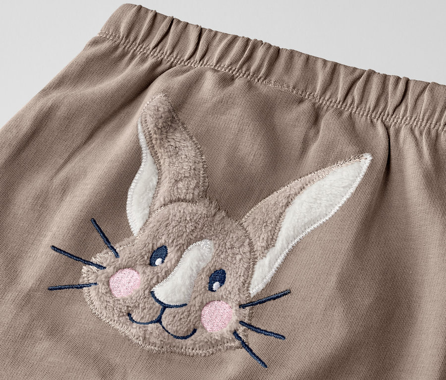 Detailaufnahme einer Babyhose mit Hasenapplikation.