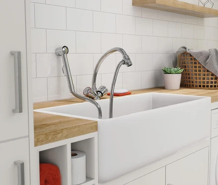 Weißes Keramikspülbecken mit Wasserhahn in einem weißen Badezimmer.