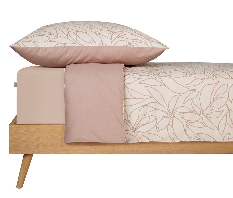 Bettwäscheset mit botanischem Blätterdruck auf einem Bett.